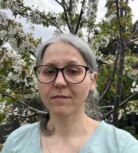 Chair of Governing Body, Roza Shirazi, looking at the camera with trees in the background.